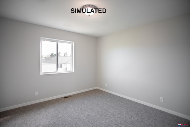 spare room with carpet, visible vents, and baseboards