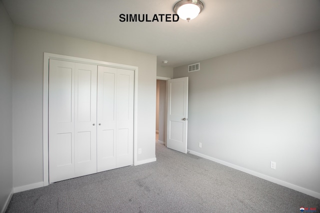 unfurnished bedroom with a closet, carpet flooring, visible vents, and baseboards