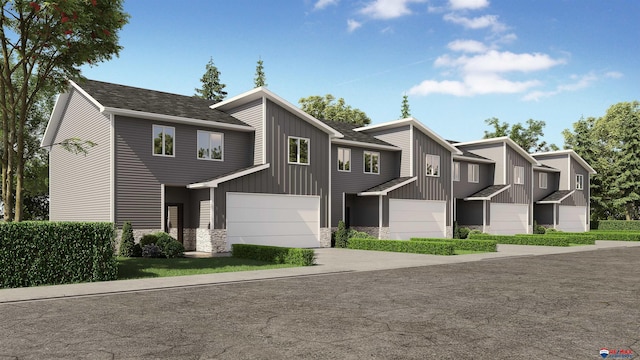 townhome / multi-family property featuring a garage, concrete driveway, board and batten siding, and stone siding