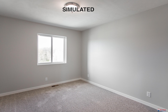 carpeted empty room featuring visible vents and baseboards