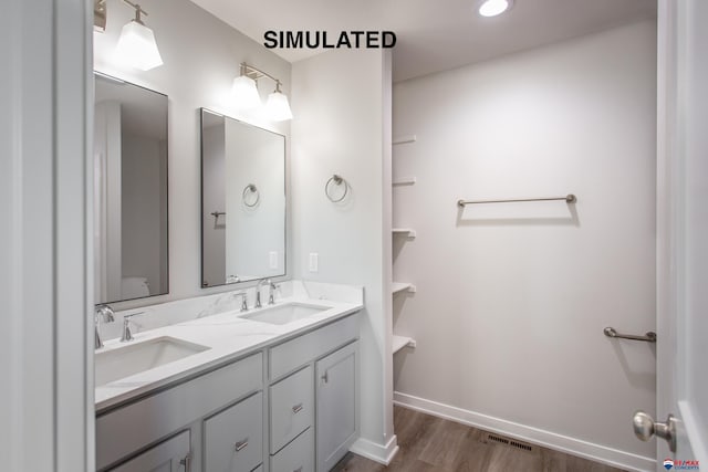 full bath with double vanity, baseboards, visible vents, and a sink