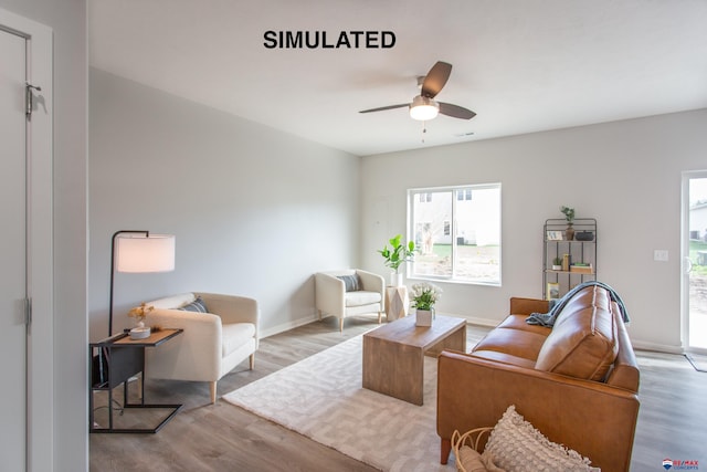 living area with ceiling fan, baseboards, and wood finished floors