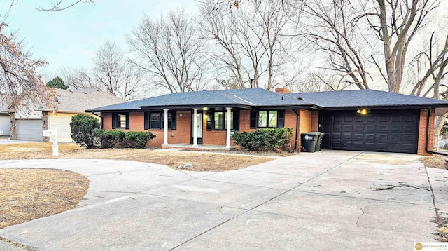 ranch-style home with concrete driveway, a garage, brick siding, and a chimney