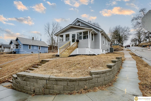 bungalow featuring central AC unit and a sunroom