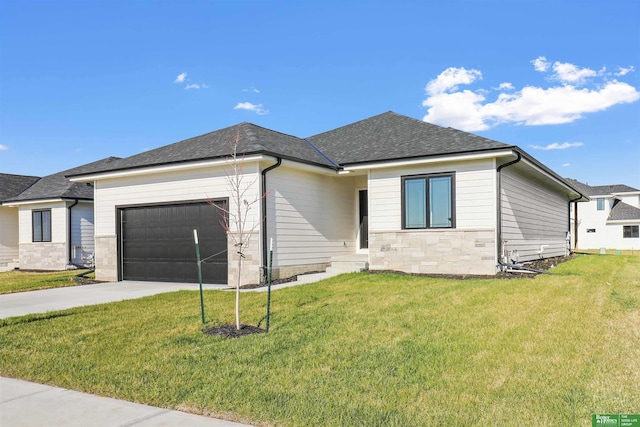 view of front of house with a shingled roof, concrete driveway, a garage, stone siding, and a front lawn