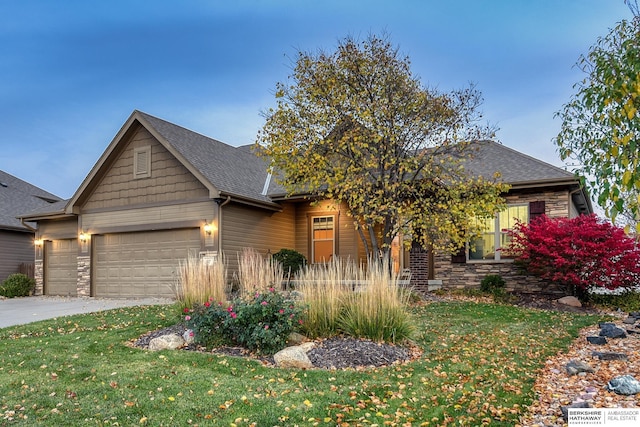 view of front facade featuring a garage, stone siding, driveway, and a front yard