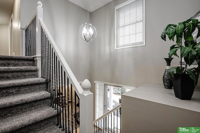 staircase with a chandelier and a towering ceiling