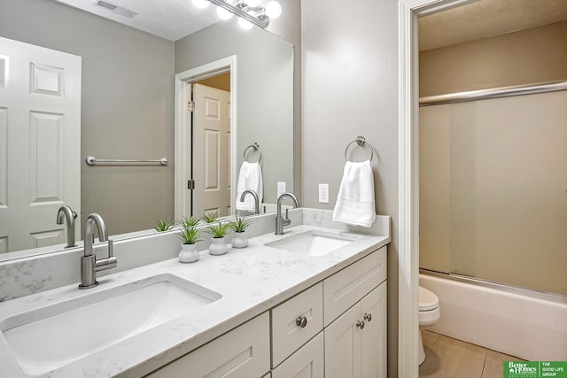 bathroom featuring toilet, a sink, visible vents, and tile patterned floors