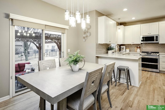 dining space featuring recessed lighting and light wood-style flooring