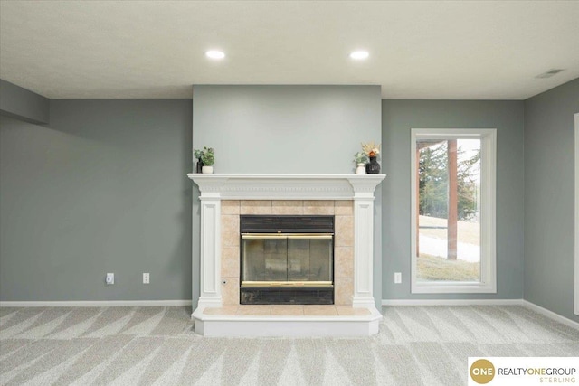 unfurnished living room featuring a tiled fireplace, carpet flooring, and recessed lighting