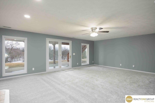 carpeted empty room with a wealth of natural light, ceiling fan, a textured ceiling, and baseboards