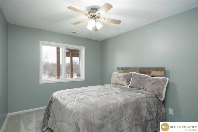 carpeted bedroom with visible vents, a ceiling fan, and baseboards