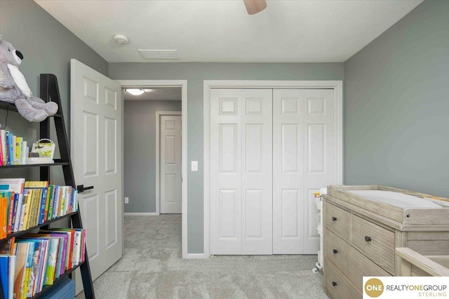 carpeted bedroom featuring a closet, visible vents, a ceiling fan, and baseboards