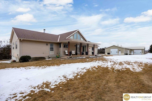 view of front of property featuring a detached garage and a porch