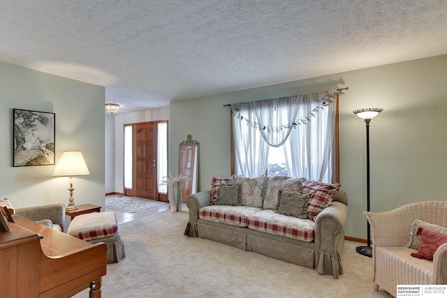 living area featuring a textured ceiling, carpet floors, and baseboards