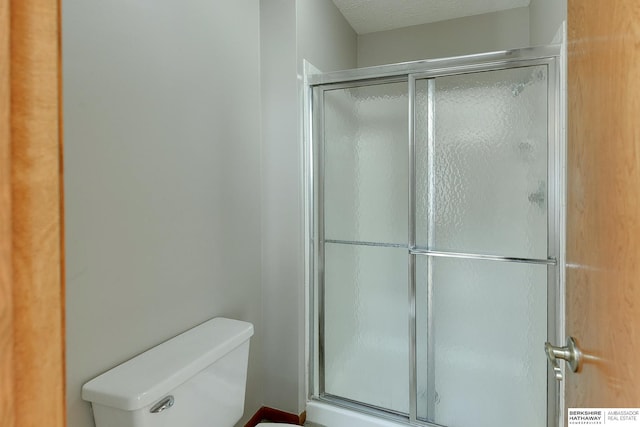 bathroom with toilet and a shower stall