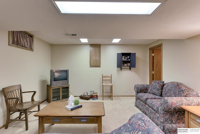 living area featuring baseboards, visible vents, and light colored carpet