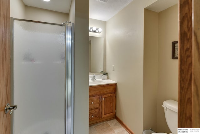 bathroom featuring toilet, a stall shower, baseboards, and vanity