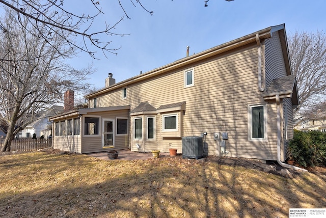 back of house featuring a patio, central AC unit, fence, a sunroom, and a chimney