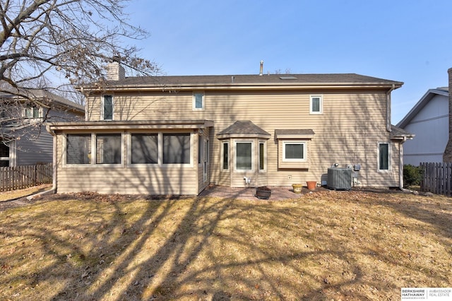 back of house with central AC, a yard, a chimney, and fence