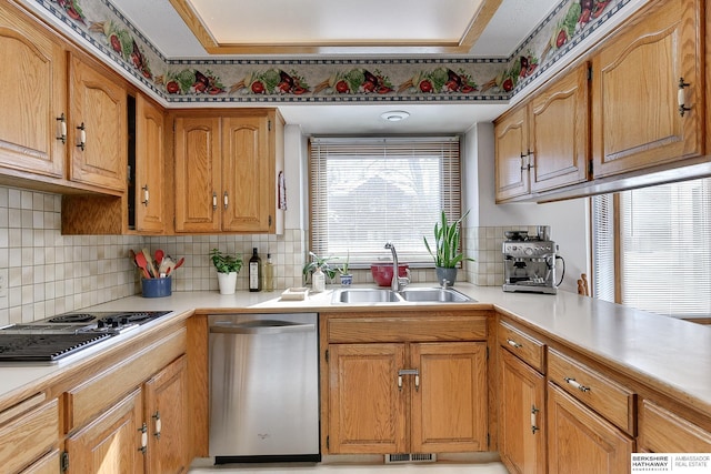 kitchen with a sink, electric cooktop, stainless steel dishwasher, and light countertops