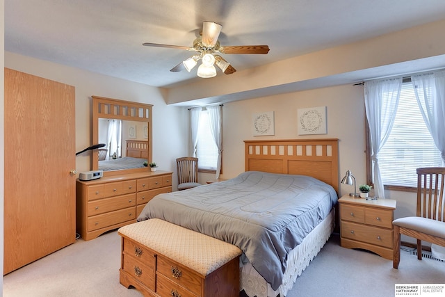 bedroom with ceiling fan, multiple windows, and light colored carpet