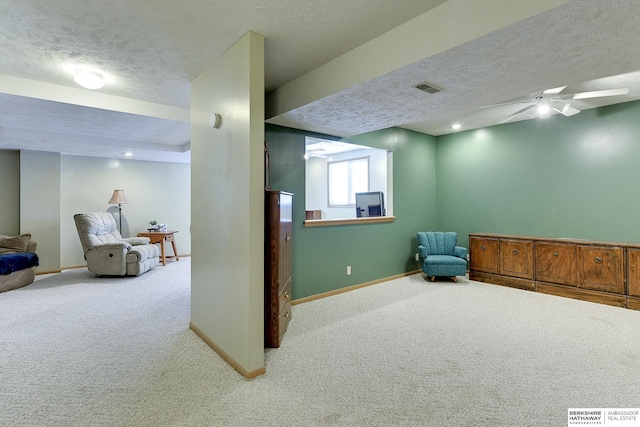 living area with carpet, visible vents, ceiling fan, and baseboards