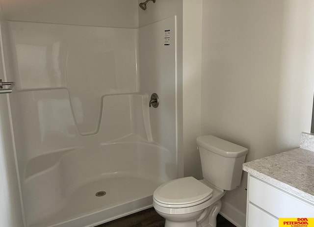 bathroom featuring a shower, vanity, and toilet