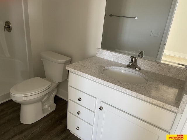 bathroom with baseboards, vanity, toilet, and wood finished floors