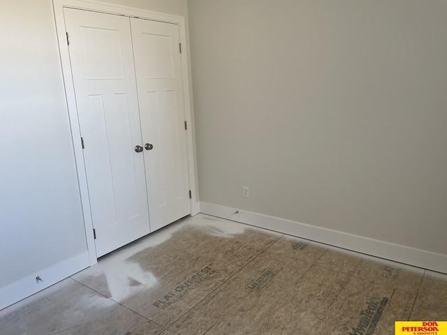 unfurnished bedroom with a closet and baseboards