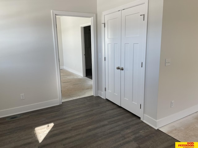 interior space featuring dark wood-type flooring and baseboards