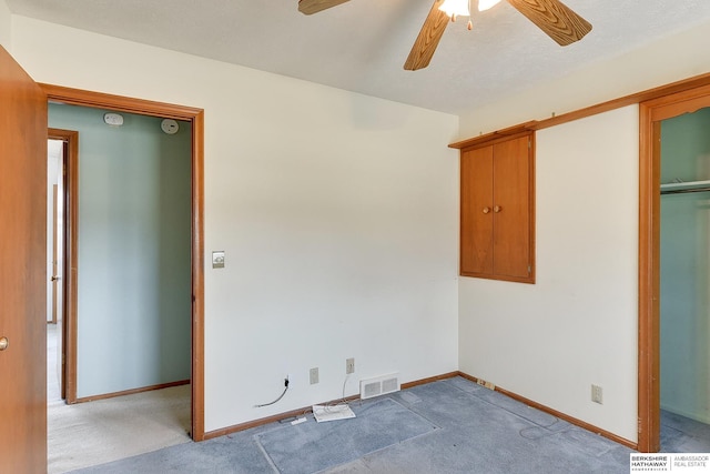 unfurnished bedroom featuring a ceiling fan, baseboards, visible vents, and light carpet