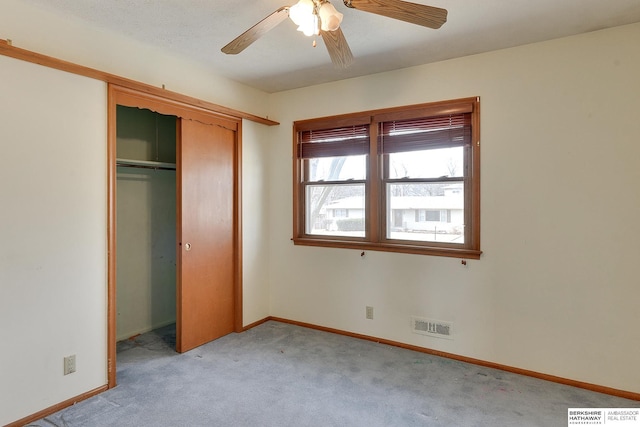 unfurnished bedroom featuring baseboards, visible vents, light carpet, and a closet