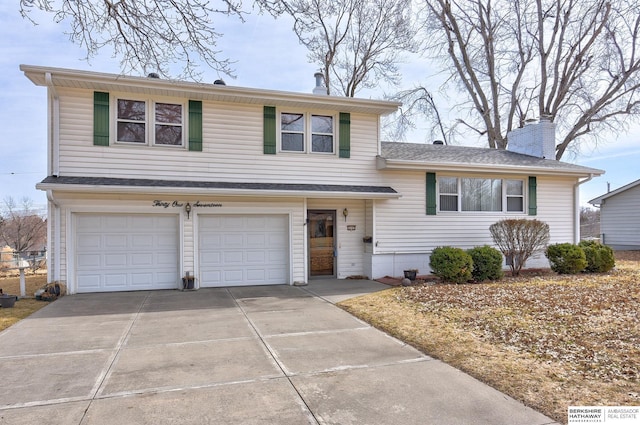 tri-level home with concrete driveway, a chimney, and a garage