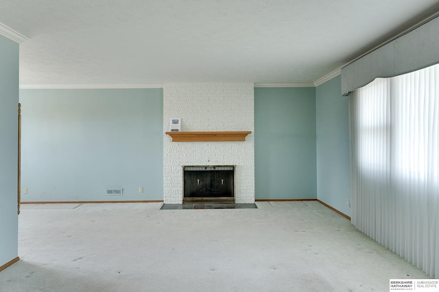 unfurnished living room with baseboards, carpet, a fireplace, and crown molding