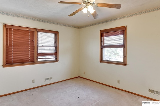 unfurnished room with visible vents, light colored carpet, and baseboards