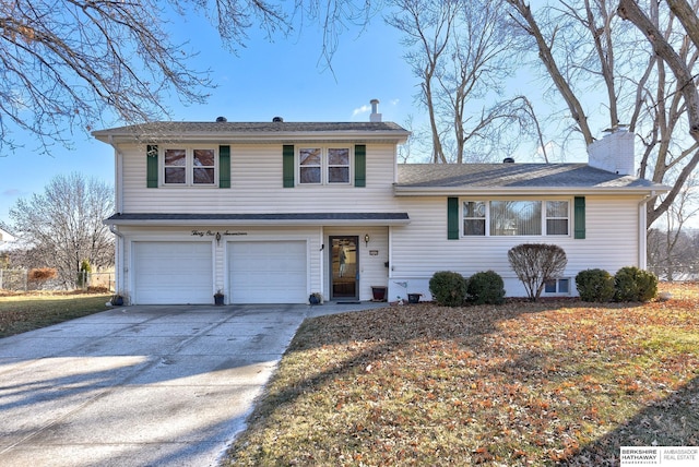 tri-level home featuring concrete driveway, a chimney, and a garage