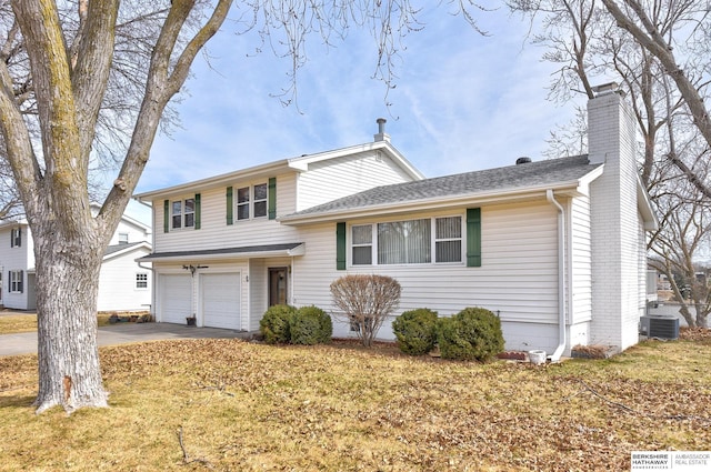 tri-level home with a front yard, central AC unit, an attached garage, a chimney, and concrete driveway