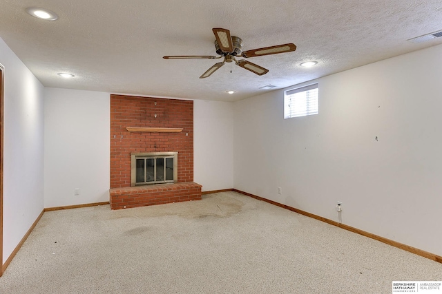 unfurnished living room featuring a brick fireplace, carpet, visible vents, and a textured ceiling