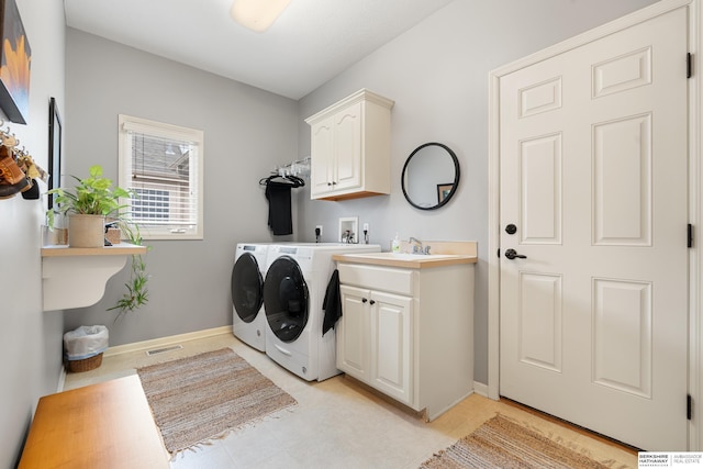 clothes washing area featuring cabinet space, baseboards, visible vents, and washer and dryer