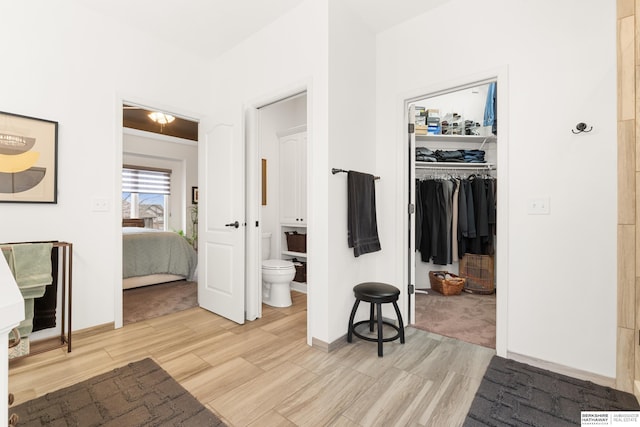 hall featuring light wood-style floors and baseboards