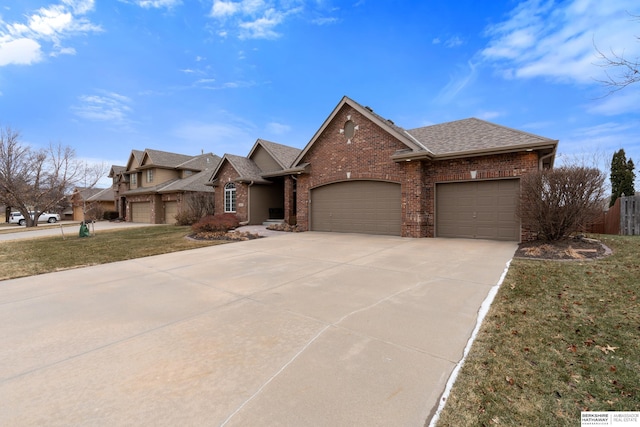 traditional-style home with brick siding, roof with shingles, concrete driveway, an attached garage, and fence