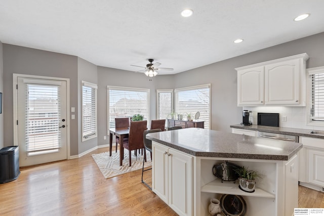 kitchen featuring a center island, white cabinetry, light wood finished floors, and open shelves