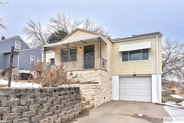 view of front of house featuring a garage, concrete driveway, and covered porch