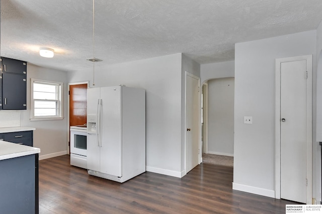 kitchen featuring white appliances, baseboards, arched walkways, dark wood finished floors, and light countertops