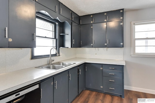 kitchen with dishwasher, dark wood-style flooring, light countertops, a textured ceiling, and a sink