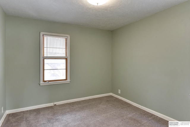 unfurnished room with carpet flooring, a textured ceiling, and baseboards