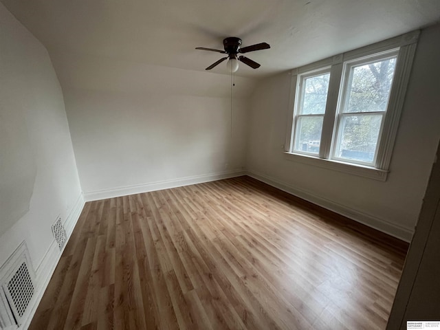 spare room featuring a ceiling fan, wood finished floors, visible vents, and baseboards