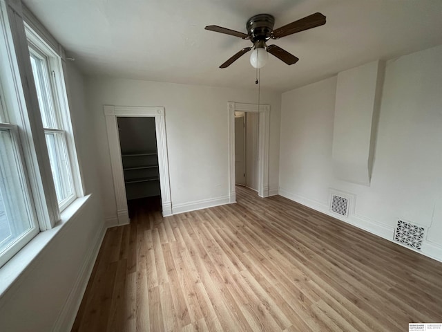 unfurnished bedroom featuring a ceiling fan, light wood-style flooring, visible vents, and baseboards