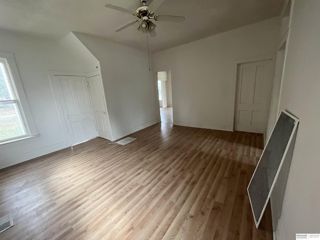 unfurnished bedroom with a closet, visible vents, ceiling fan, and wood finished floors